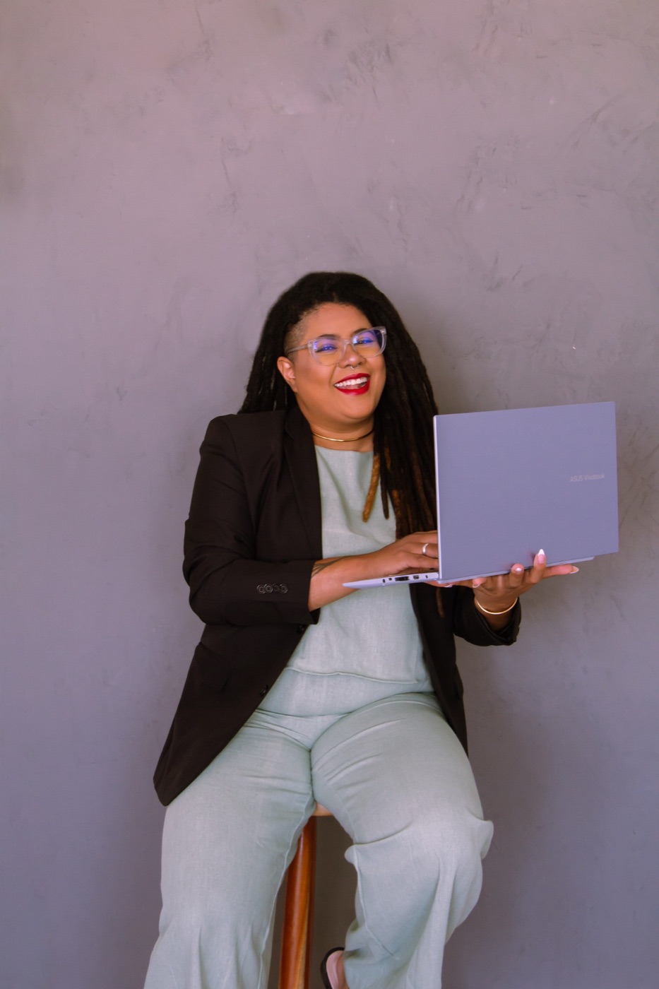 Louise Nunes, fundadora da LN Soluções, sorrindo com um notebook nas mãos
